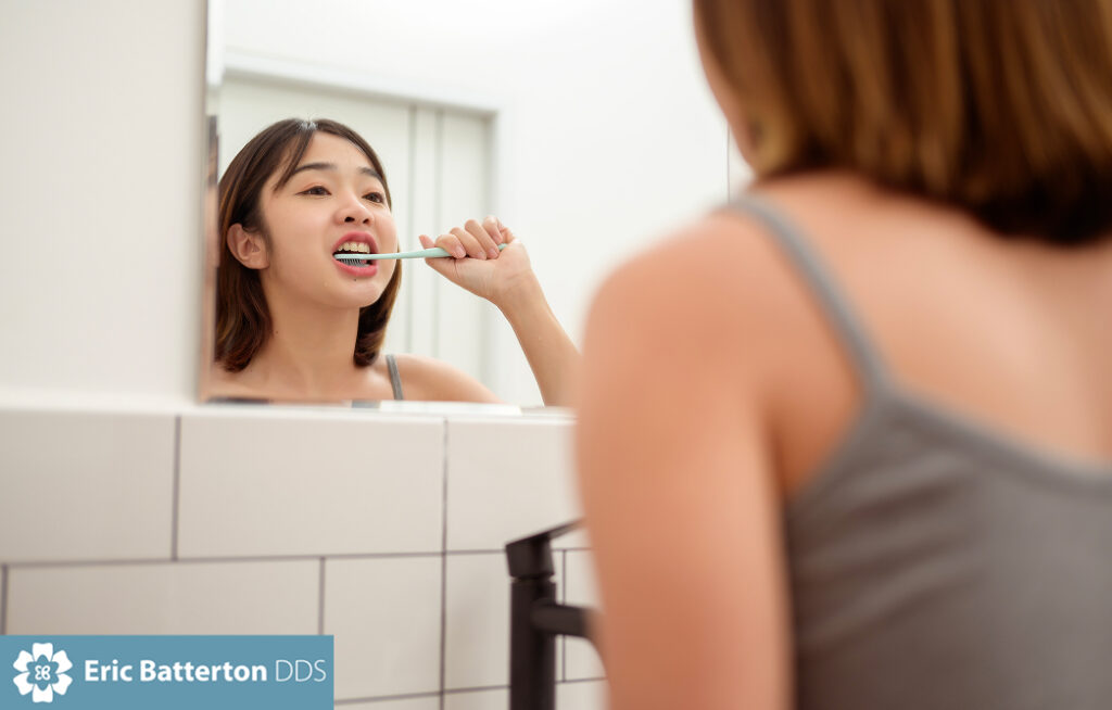 A young woman brushing her teeth in restroom