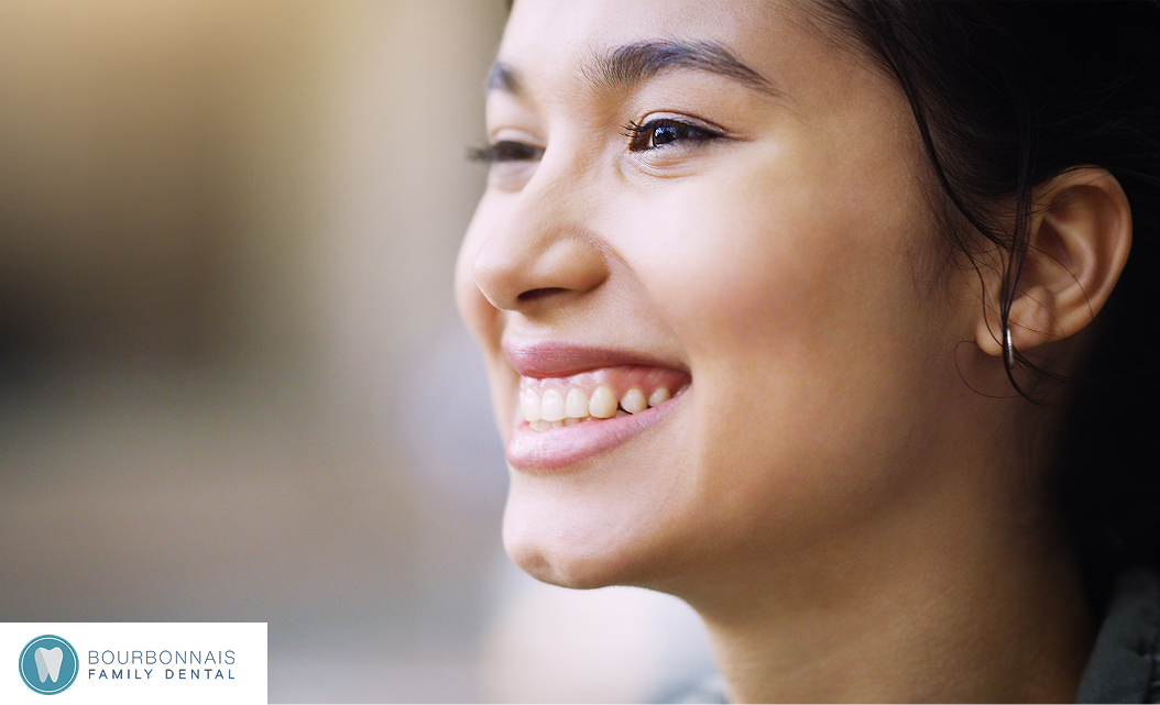 Side view of a woman smiling, showing healthy white teeth.
