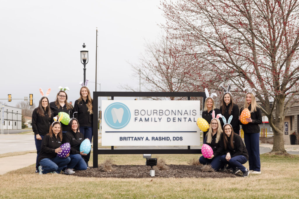 Bourbonnais Family Dental team holding Easter eggs wearing bunny ears.