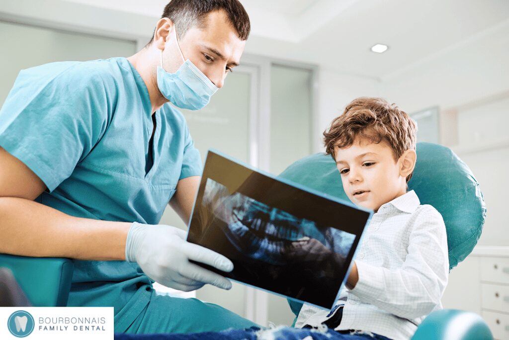 Dentist showing dental X-ray to young boy in office